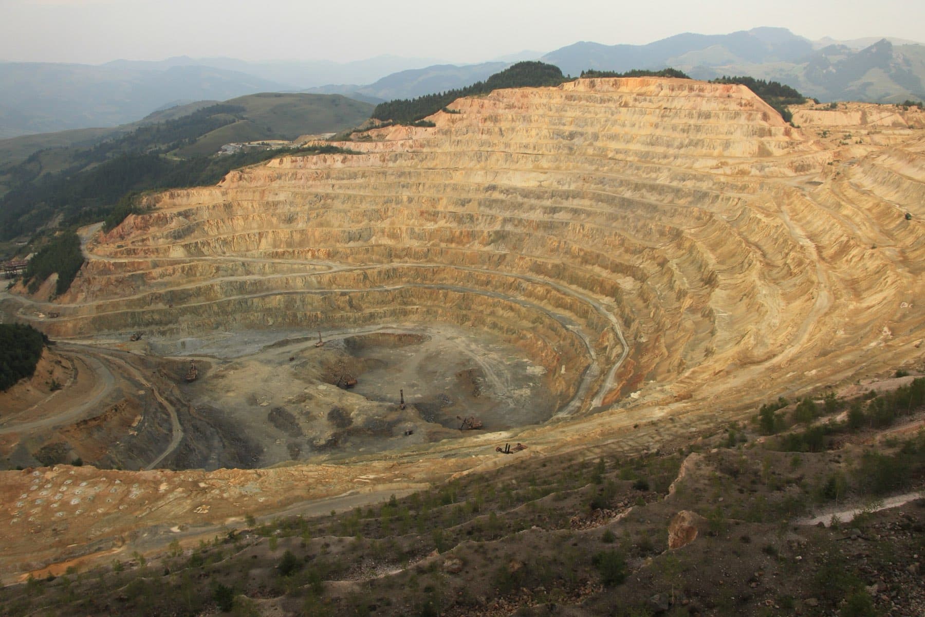 An open pit copper mine cut in benches down to the working floor.