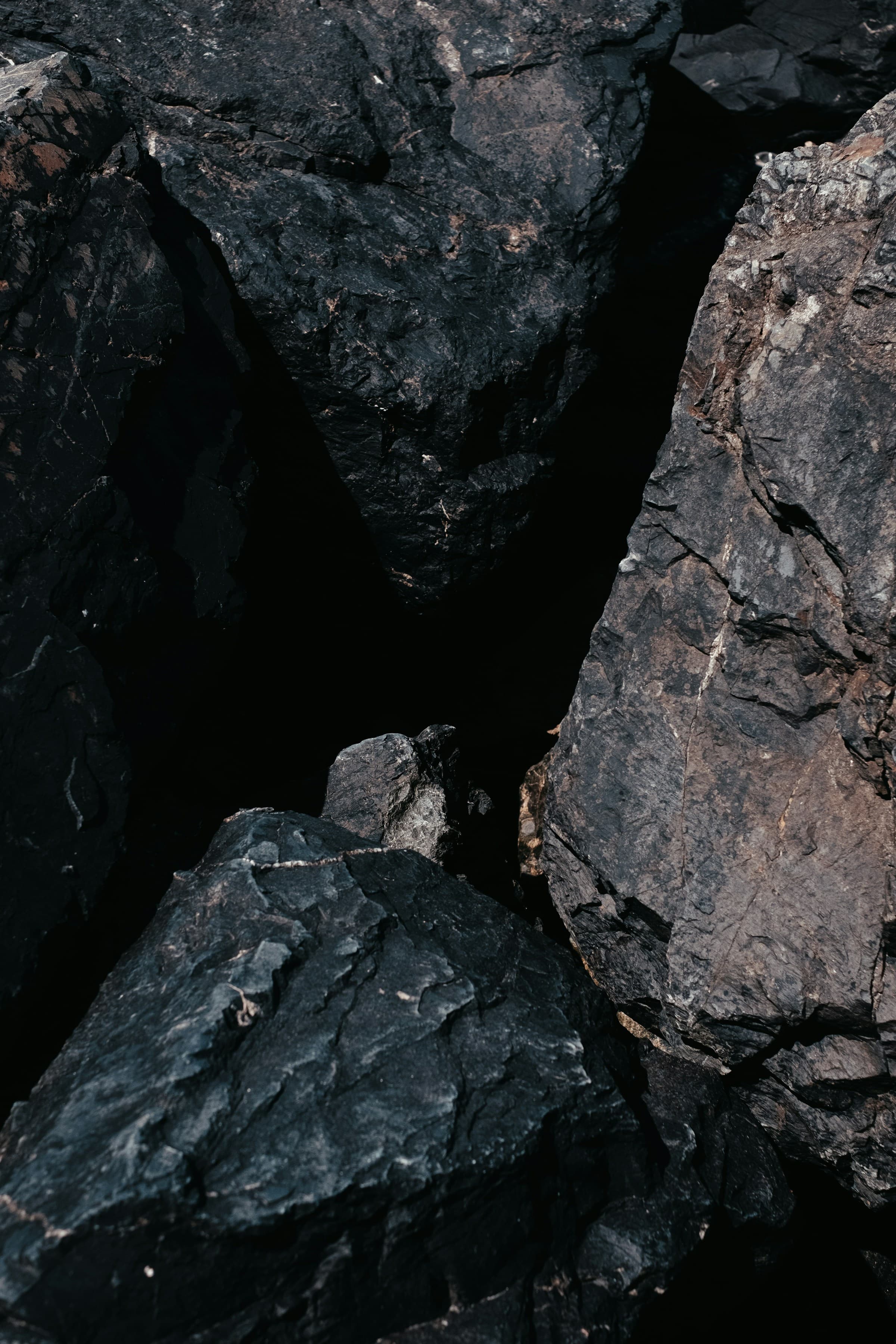 Close detail of dark fractured rock showing the grain and break faces