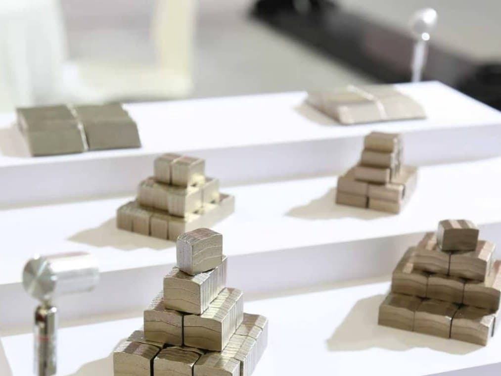 Diamond saw segments stacked in grades on a white display bench