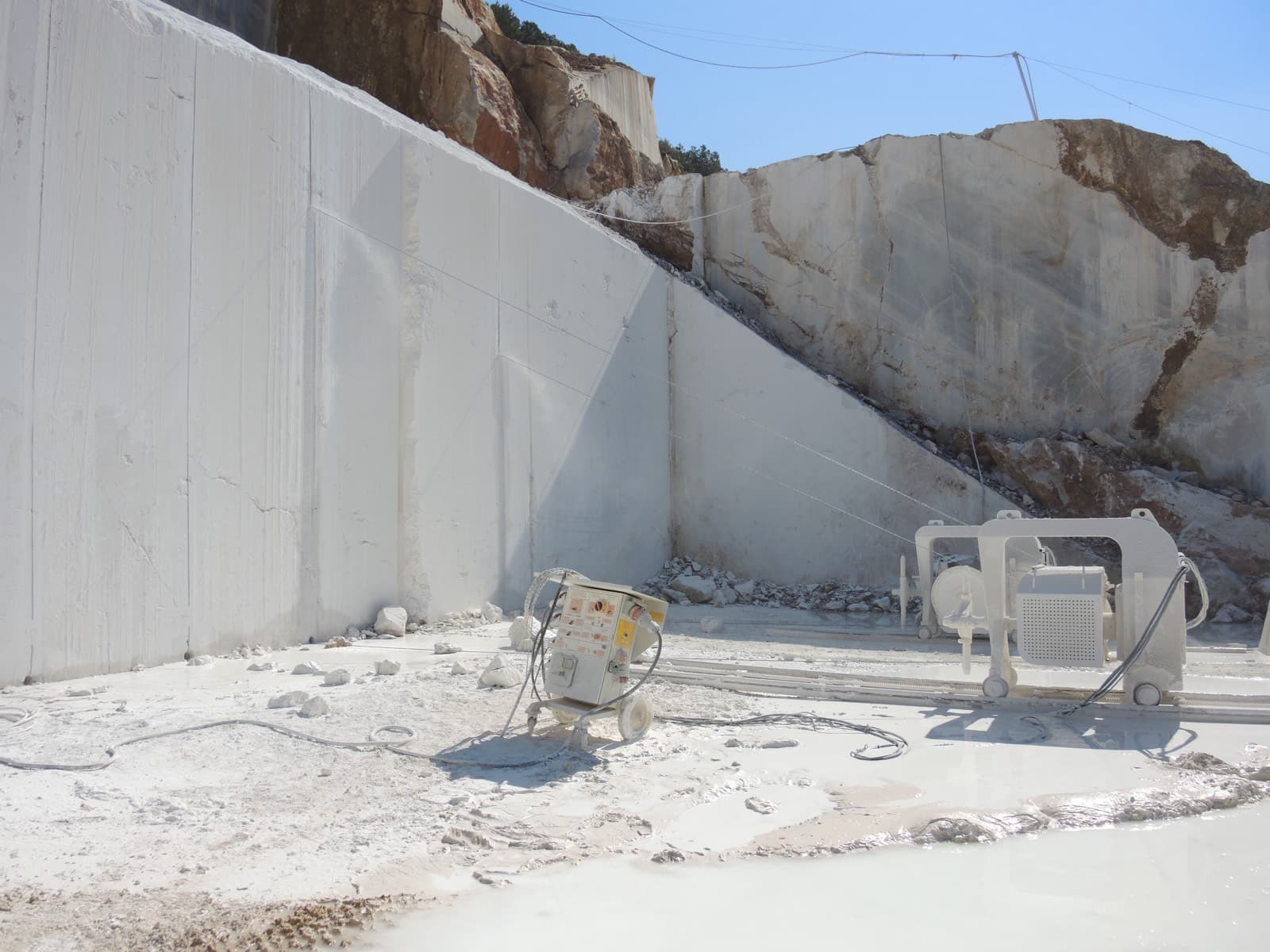 Diamond wire saw machine mounted on rails at a quarry bench