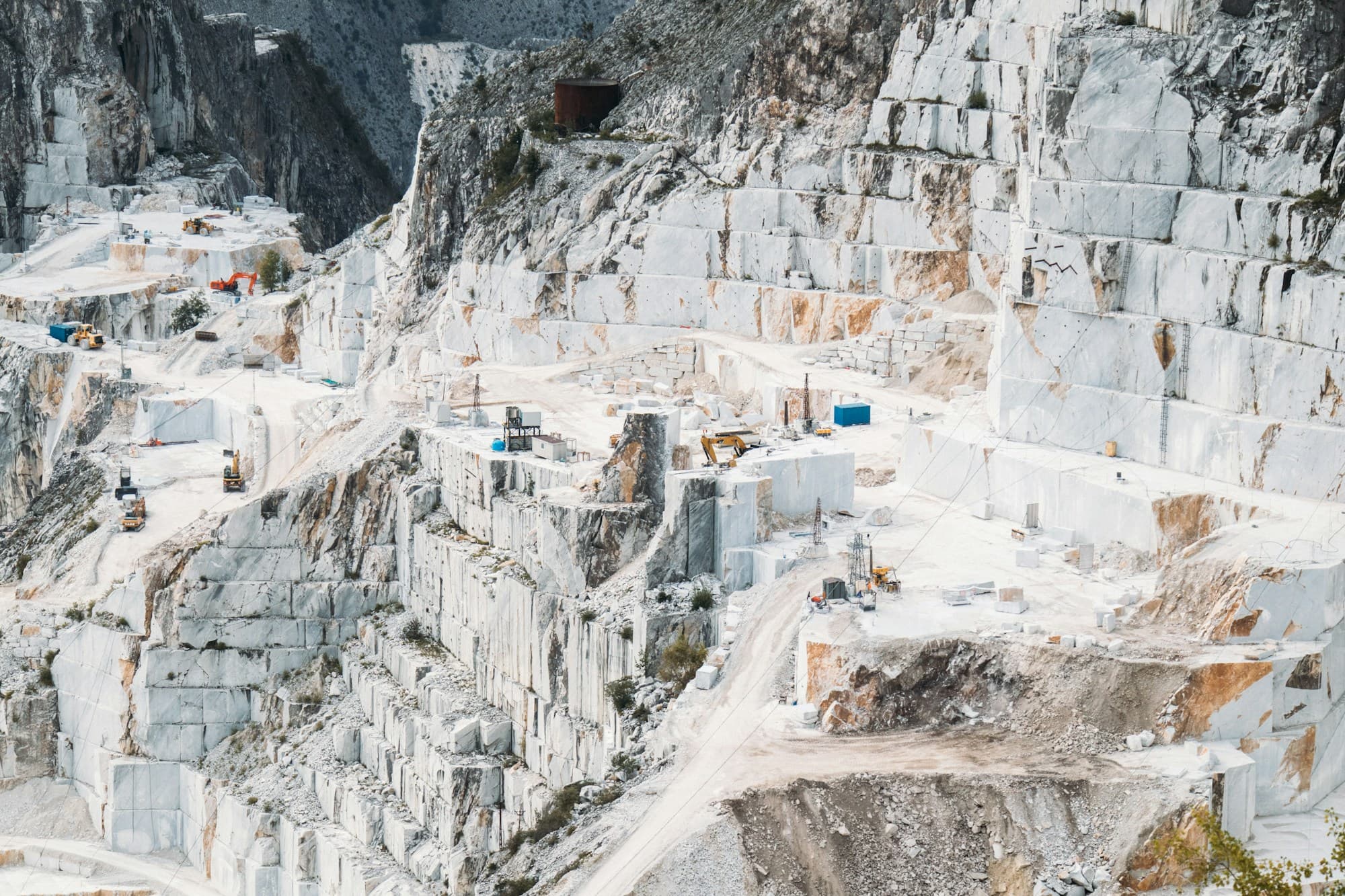 White marble quarry benches cut into dry pale rocky hills in Mohmand